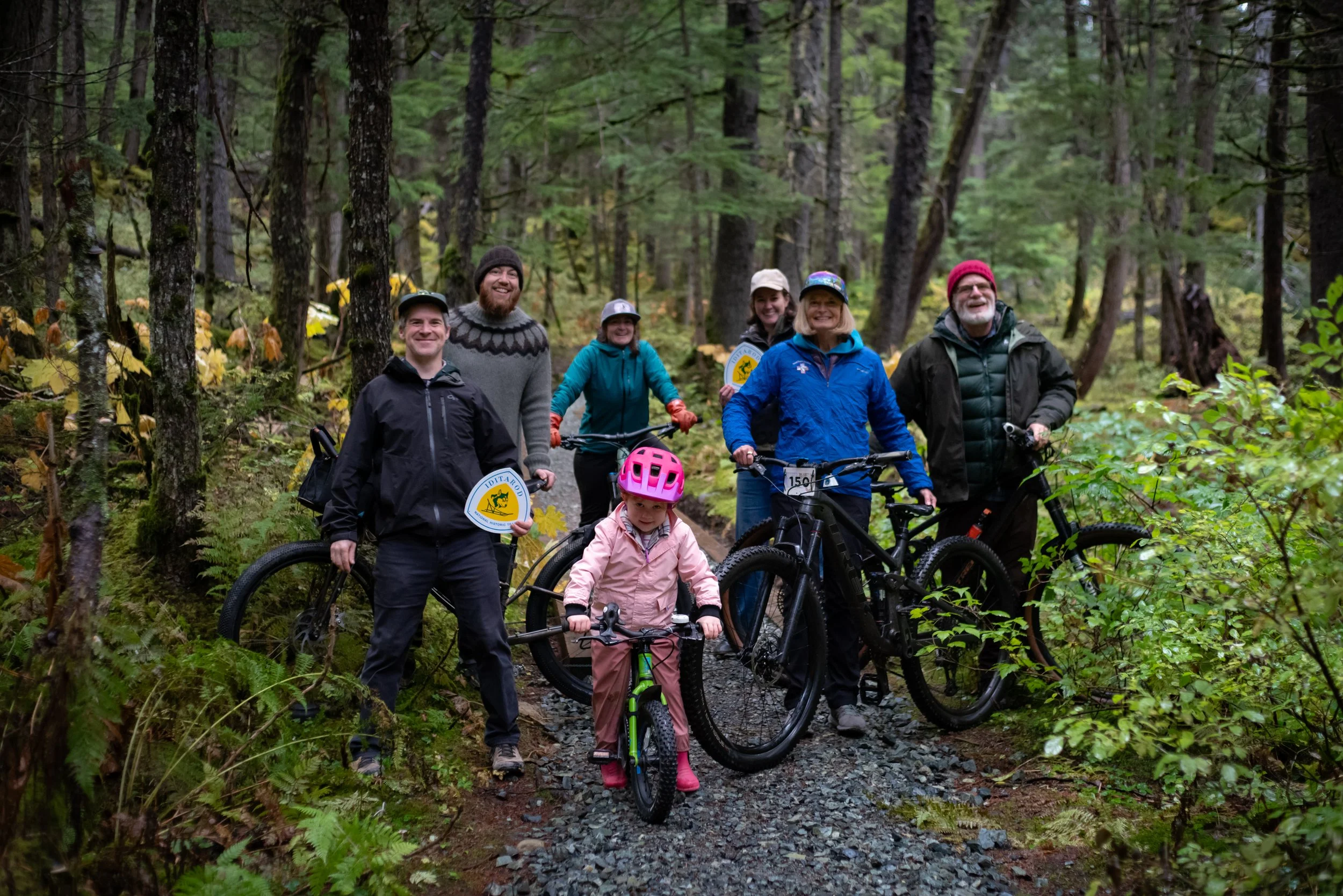 Senator Lisa Murkowski with Alaska outdoor recreation advocates on a forest trail during the October 2026 Iditarod trail visit.